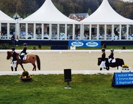 Zwei Reiterinnen auf Pferden während eines Reitturniers.